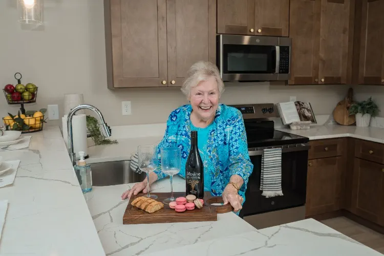 Resident preparing a cheese board in her cottage kitchen